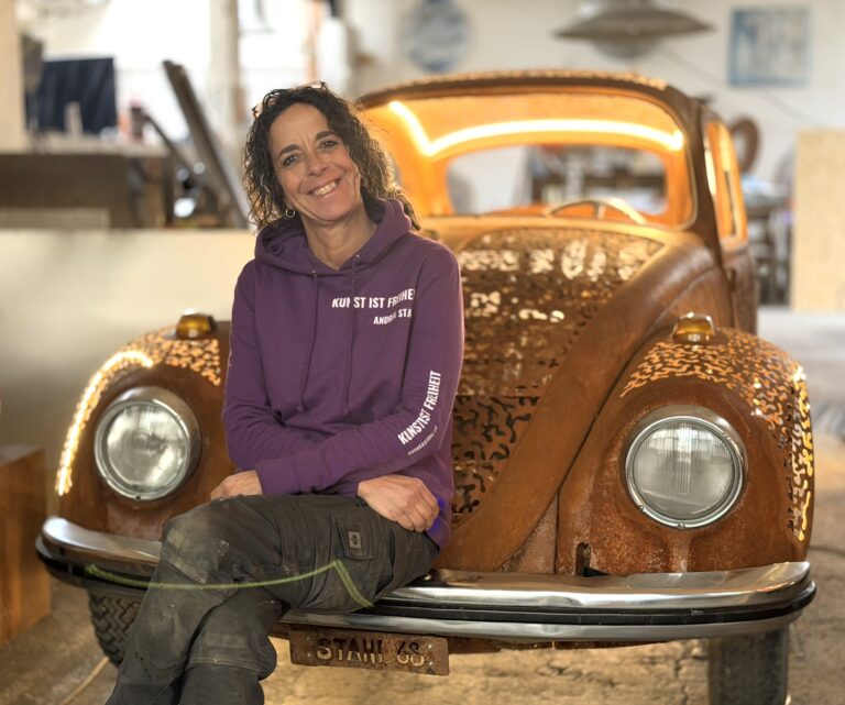 Andrea Stahl sitz auf der Stossstange beim VW Käfer